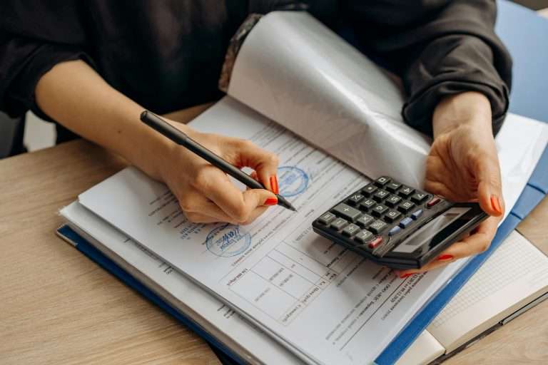 A person using a calculator to represent automotive finance compliance as part of the RTS Academy course.