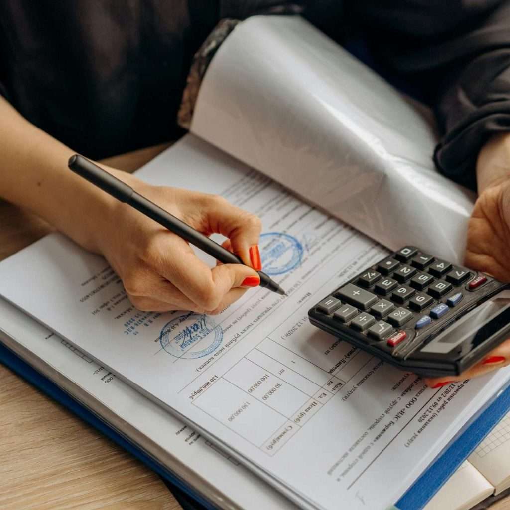 A person using a calculator to represent automotive finance compliance as part of the RTS Academy course.