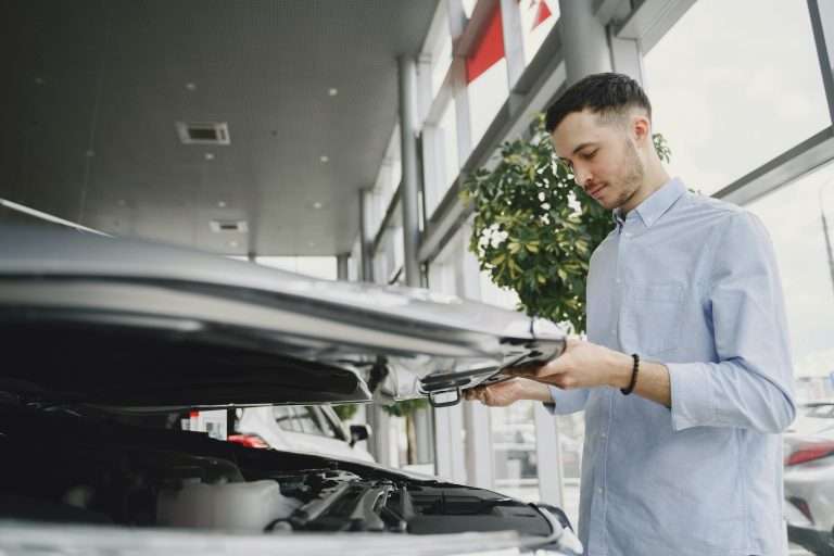 A prospective customer in a car dealership lifting the bonnet (hood) of a car. For the featured image on the RTS Academy's Identifying Customer Needs course.