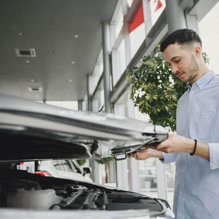A prospective customer in a car dealership lifting the bonnet (hood) of a car. For the featured image on the RTS Academy's Identifying Customer Needs course.