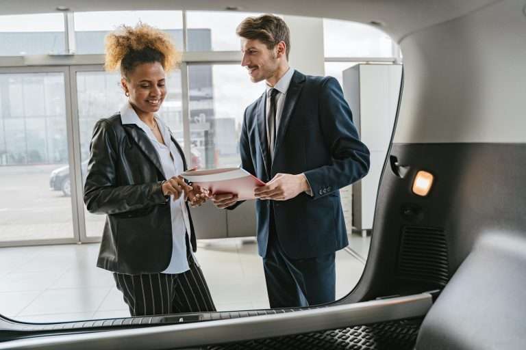 A man and a woman in an automotive dealership for the RTS Academy's Renewals course.