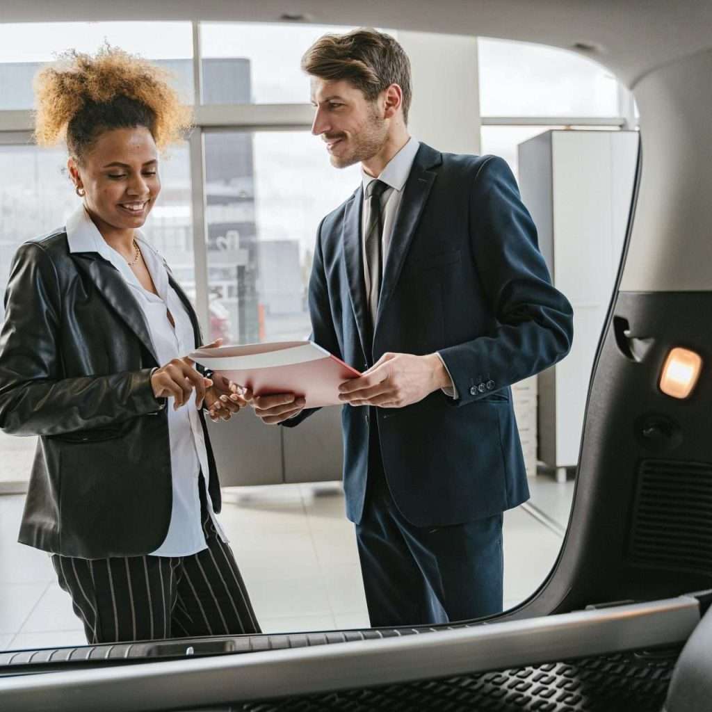 A man and a woman in an automotive dealership for the RTS Academy's Renewals course.