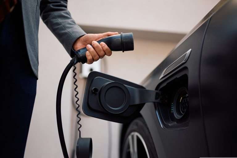 A person about to plug in an electric vehicle and start charging it for the image to the RTS Academy "The EV Landscape" eLearning course.