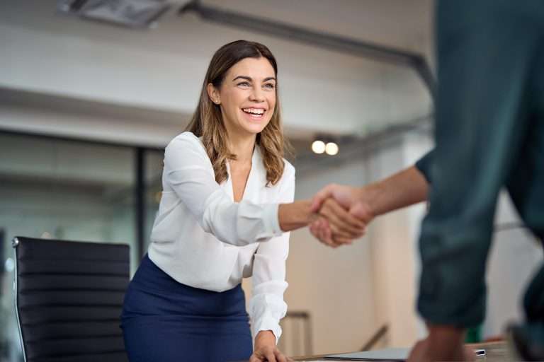 A man and a woman shaking hands, having closed a deal. For the negotiating and closing course with RTS Academy.