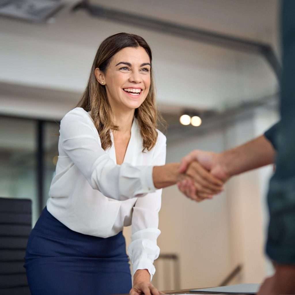 A man and a woman shaking hands, having closed a deal. For the negotiating and closing course with RTS Academy.
