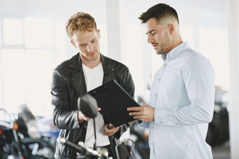Two people in a dealership. One a salesman, the second a prospective customer. For the Prospecting courses through the RTS Academy.