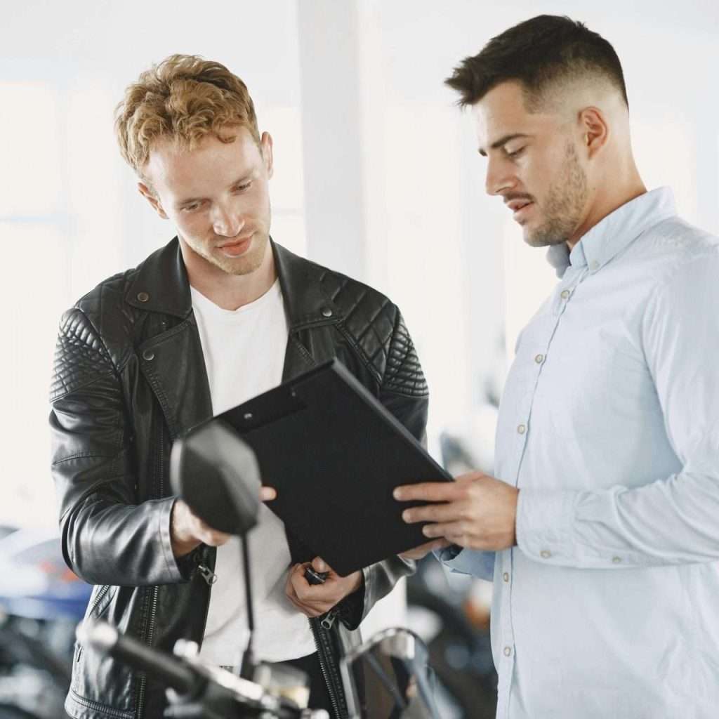 Two people in a dealership. One a salesman, the second a prospective customer. For the Prospecting courses through the RTS Academy.
