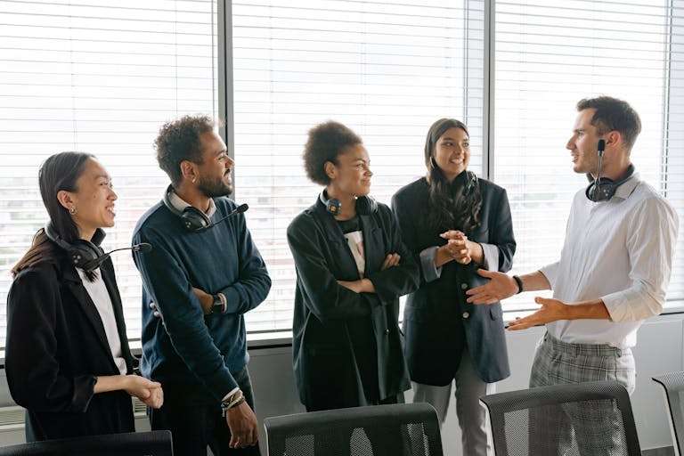 A diverse group of professionals having a conversation in a modern office environment.