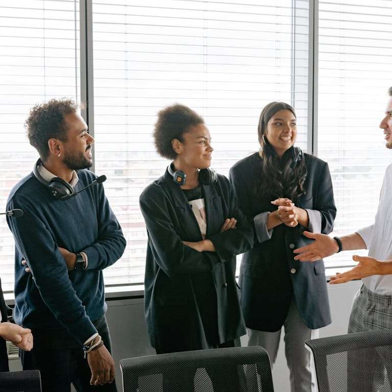 A diverse group of professionals having a conversation in a modern office environment.