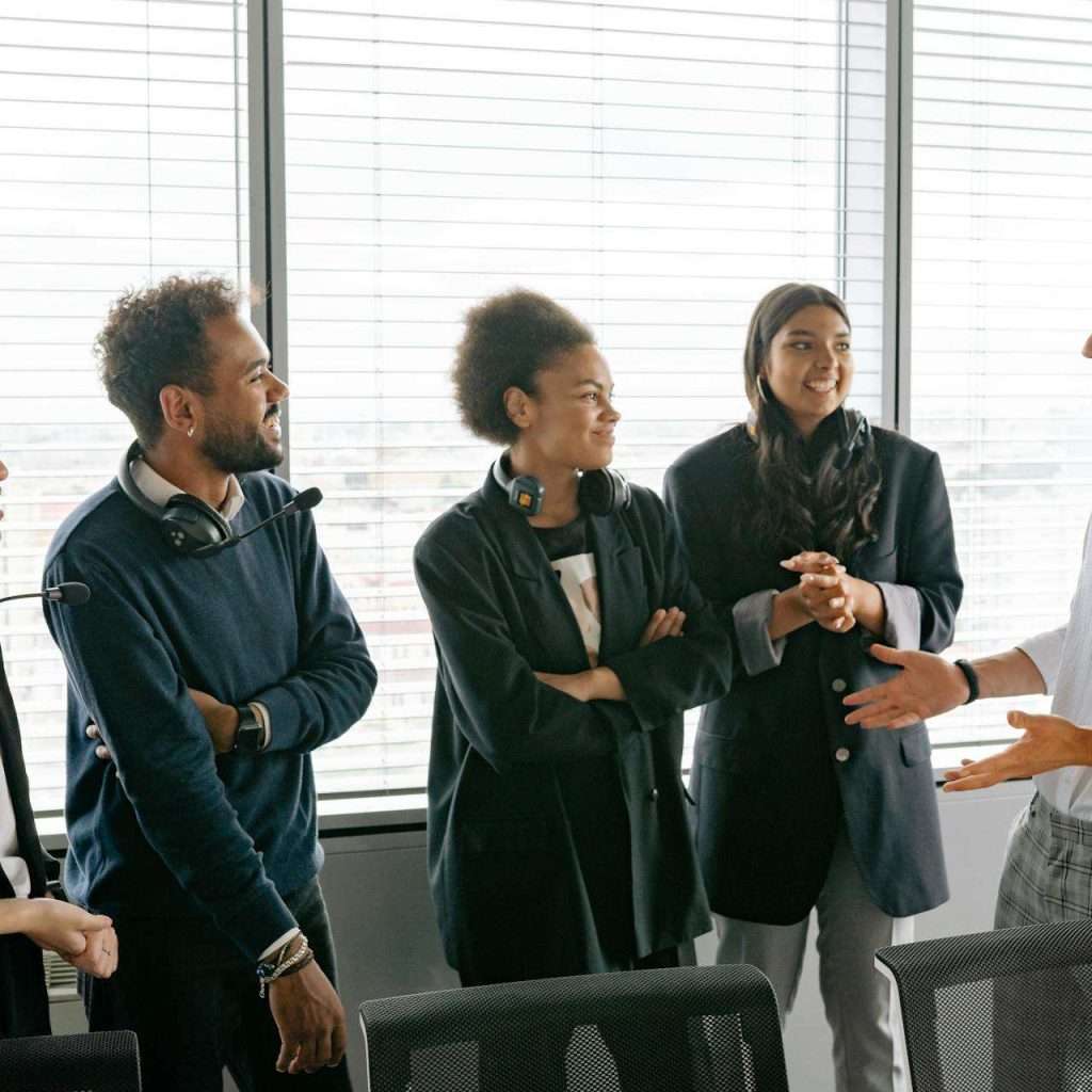 A diverse group of professionals having a conversation in a modern office environment.