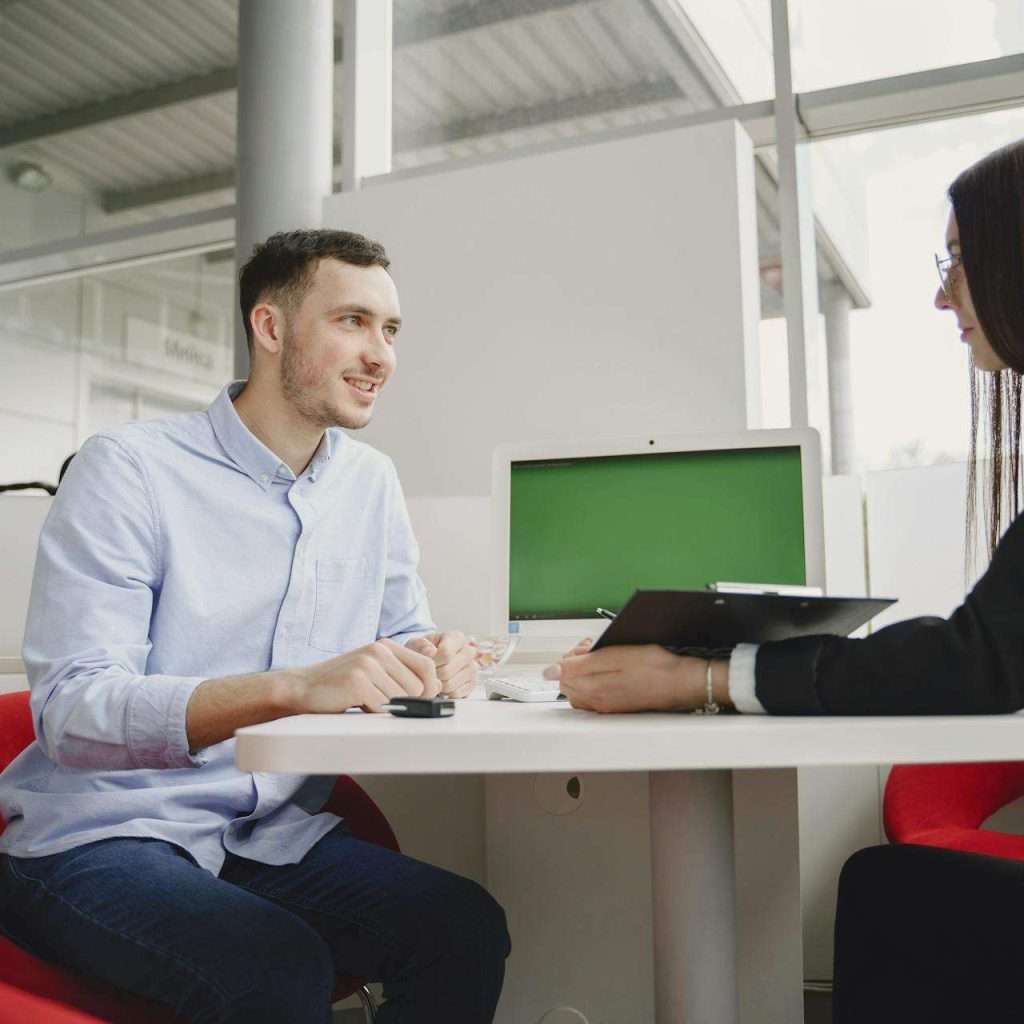 A man and woman engaged in a professional meeting at a modern office table.