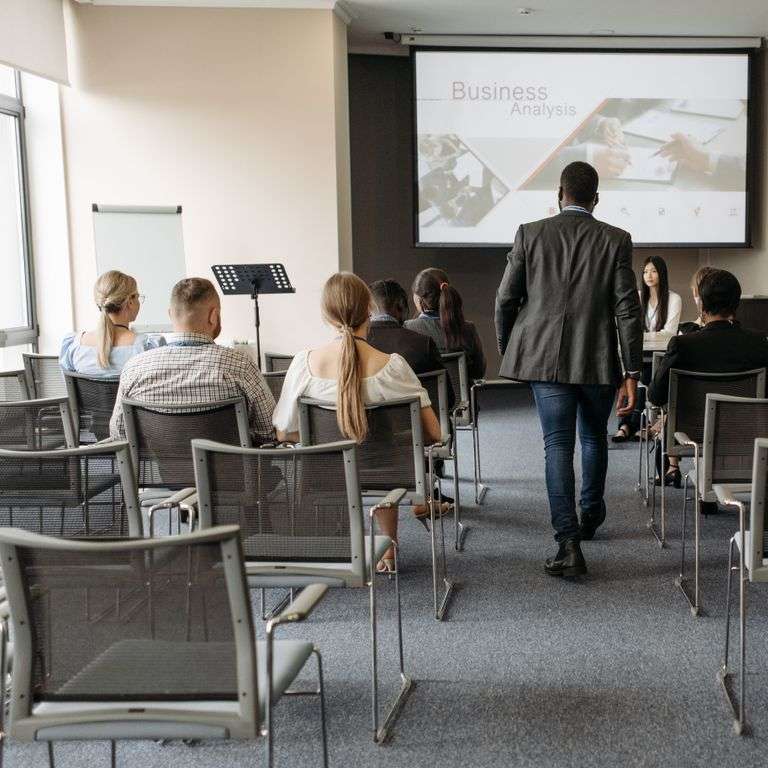 Business conference setting with diverse participants focusing on analysis presentation.
